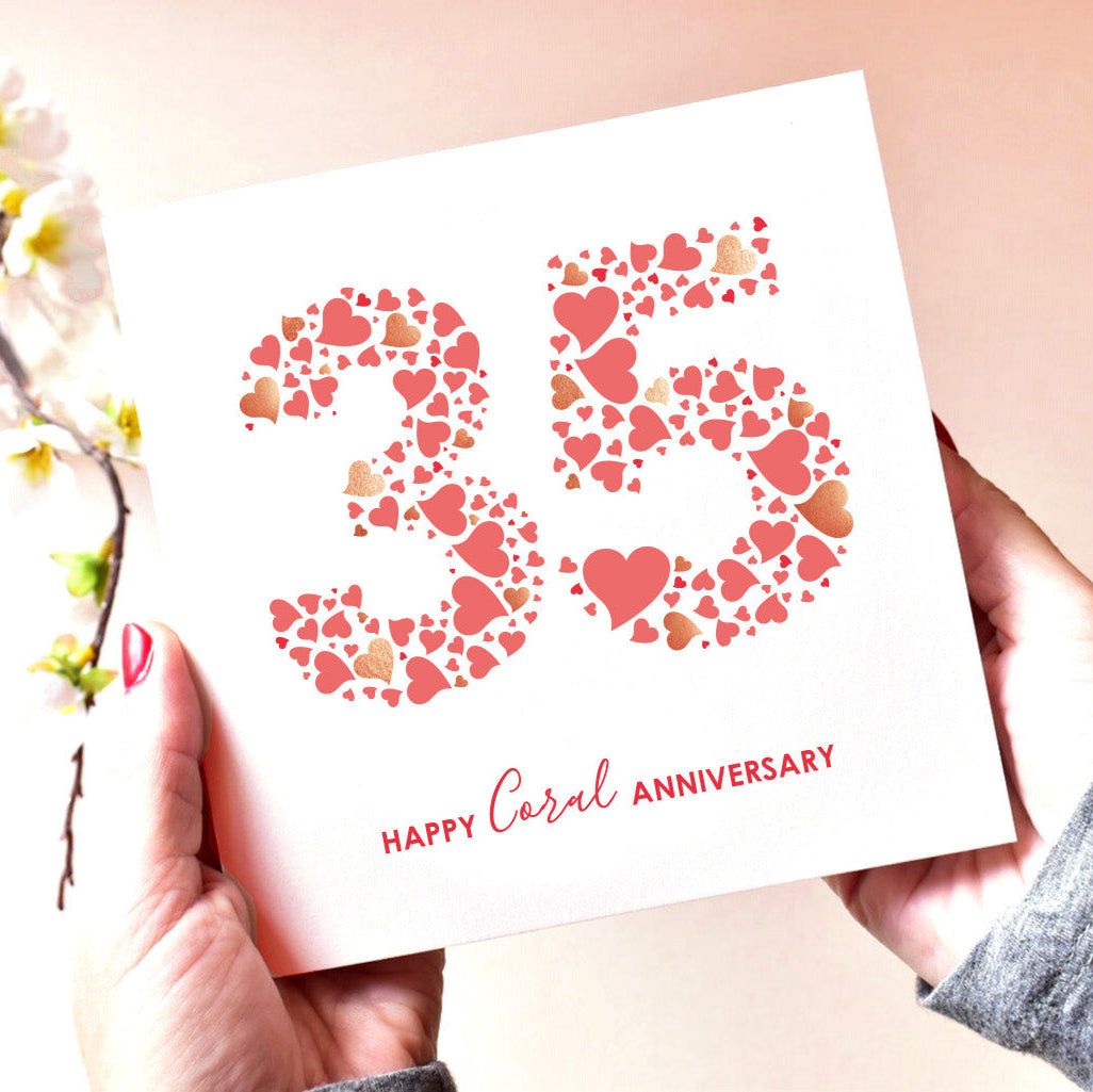 Elegant 35th anniversary card displayed alongside flowers, highlighting its warm coral hues and celebratory design.