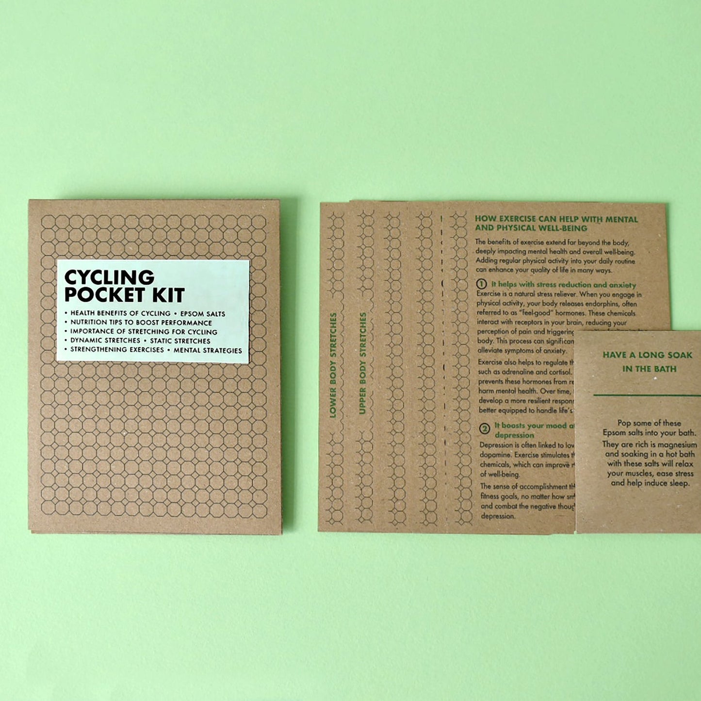 Cycling Pocket Kit contents laid out showing the kraft wallet, instructional cards and Epsom salts packet.