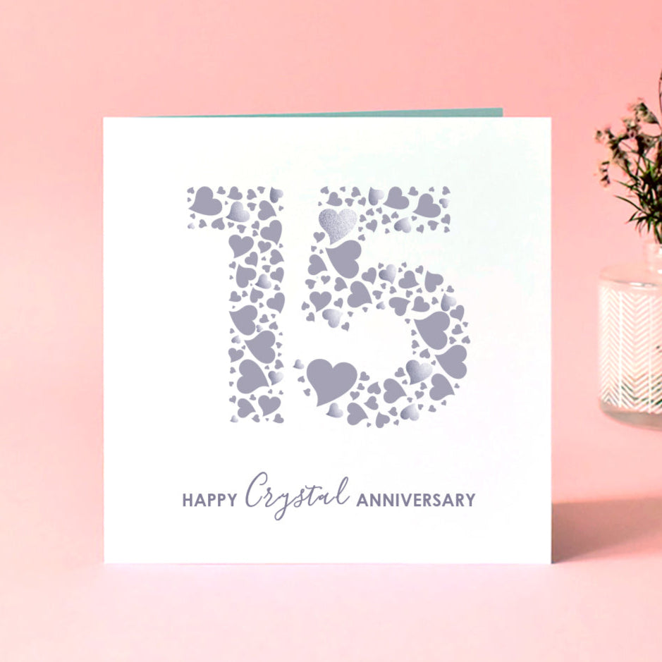 Card with heart design and 'Happy Crystal Anniversary' text on a pink background