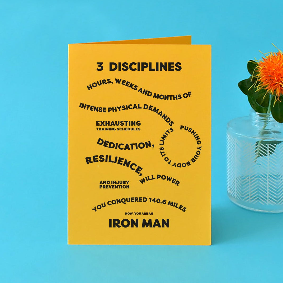 Bright yellow A6 card with bold, black text reading "3 disciplines, hours, weeks and months of intense physical demands, exhausting training schedules, pushing your body to the limits, dedication, resilience, will power and injury prevention, you conquered 140.6 miles. Now you're an Ironman."
