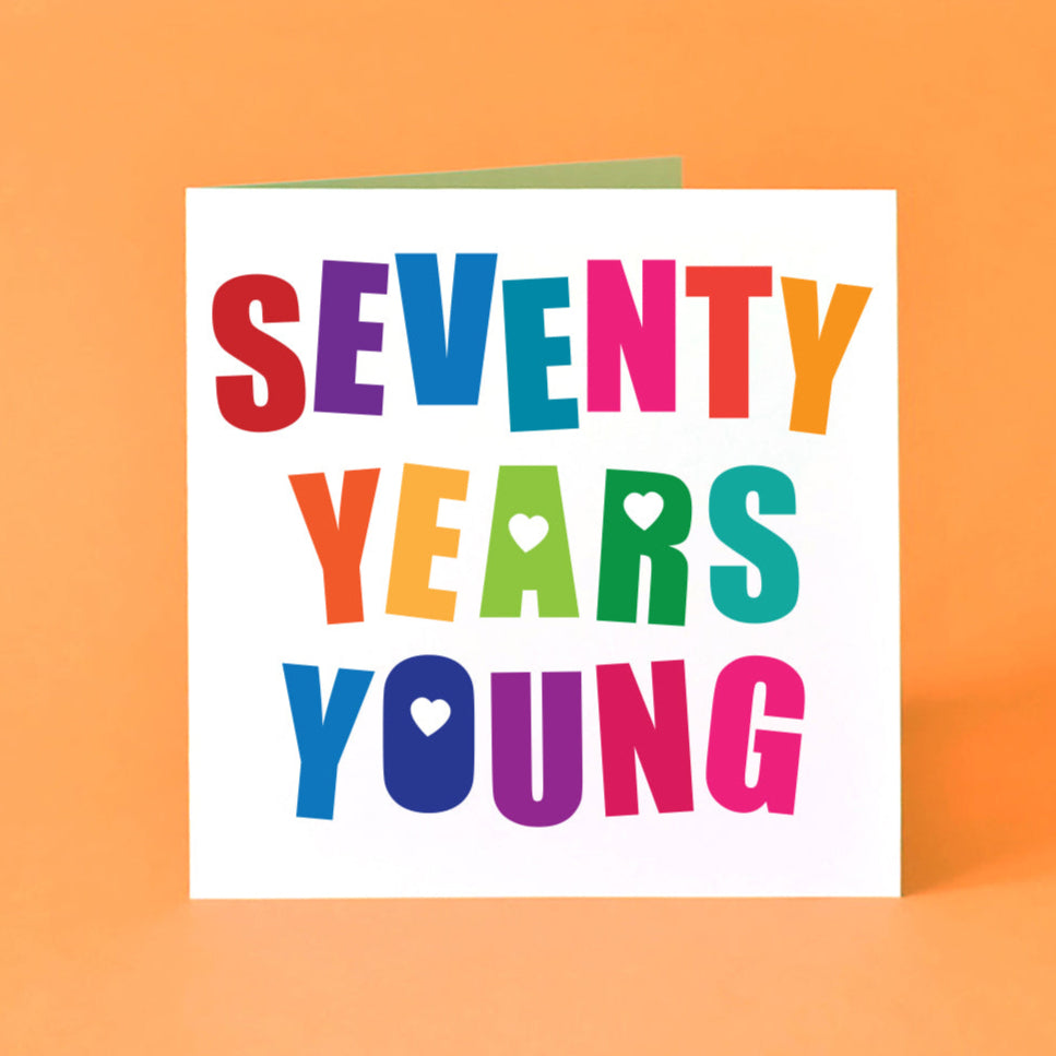 Square white birthday card featuring large, bold, angled, multicoloured "Seventy Years Young".  Design includes playful love hearts and a fun typeface. Ideal for a 70th birthday celebration or milestone.