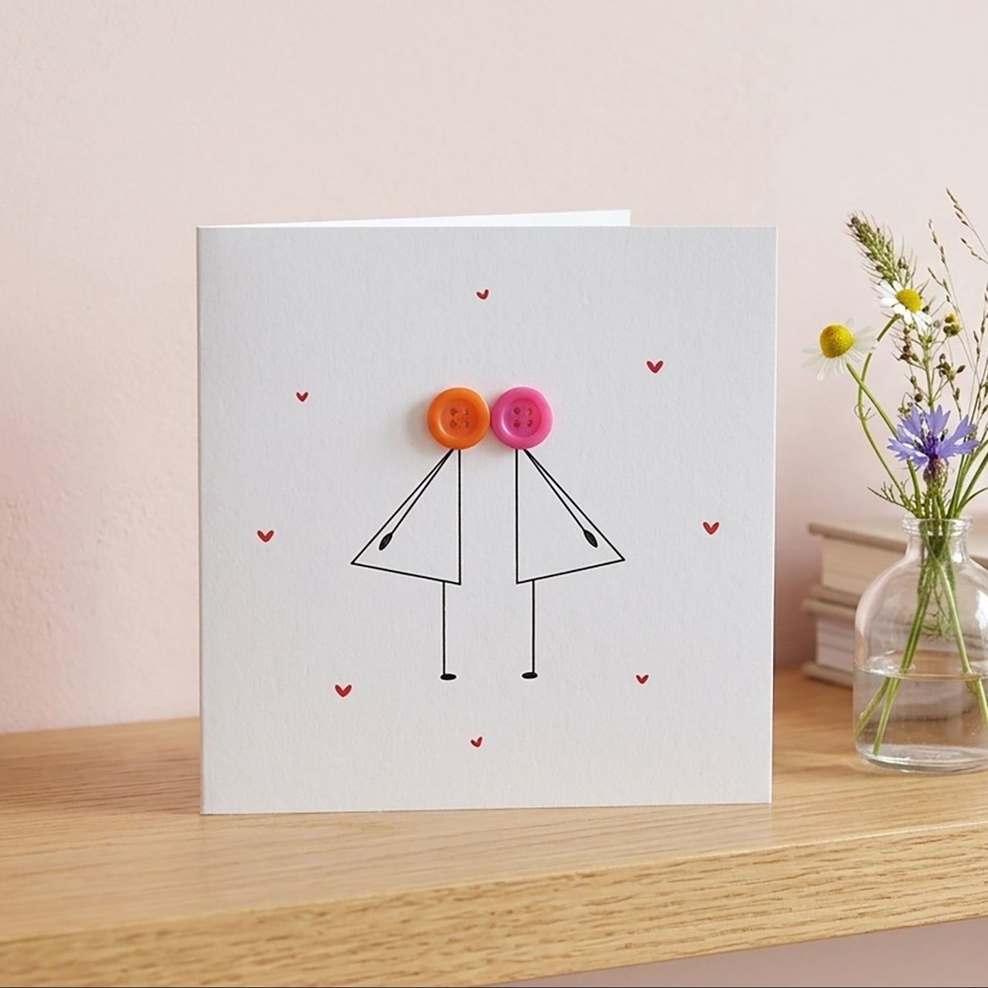 Greeting card with two female stick figures with colourful button heads.