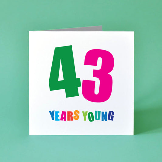 A striking '43', each digit in a different vibrant shade and set at a dynamic angle. "Years Young" sits underneath, smaller but just as bright, with each letter adding to the card's playful energy.