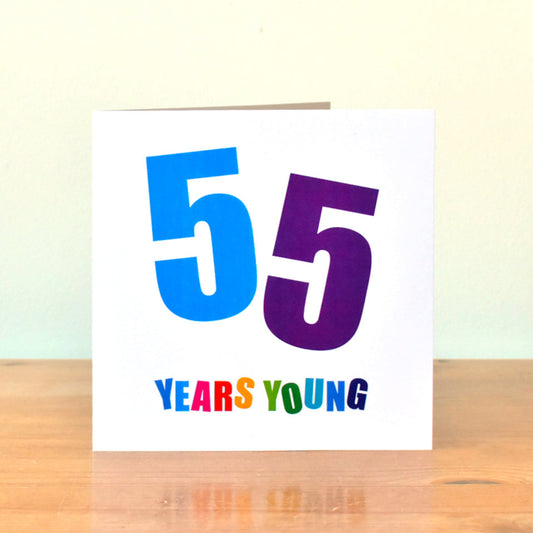 Square white birthday card showing the large, bold number "55." Each "5" is set at a different angle and in a different bold colour, blue and purple. The phrase "Years Young" appears below, with every letter in its own bold colour.