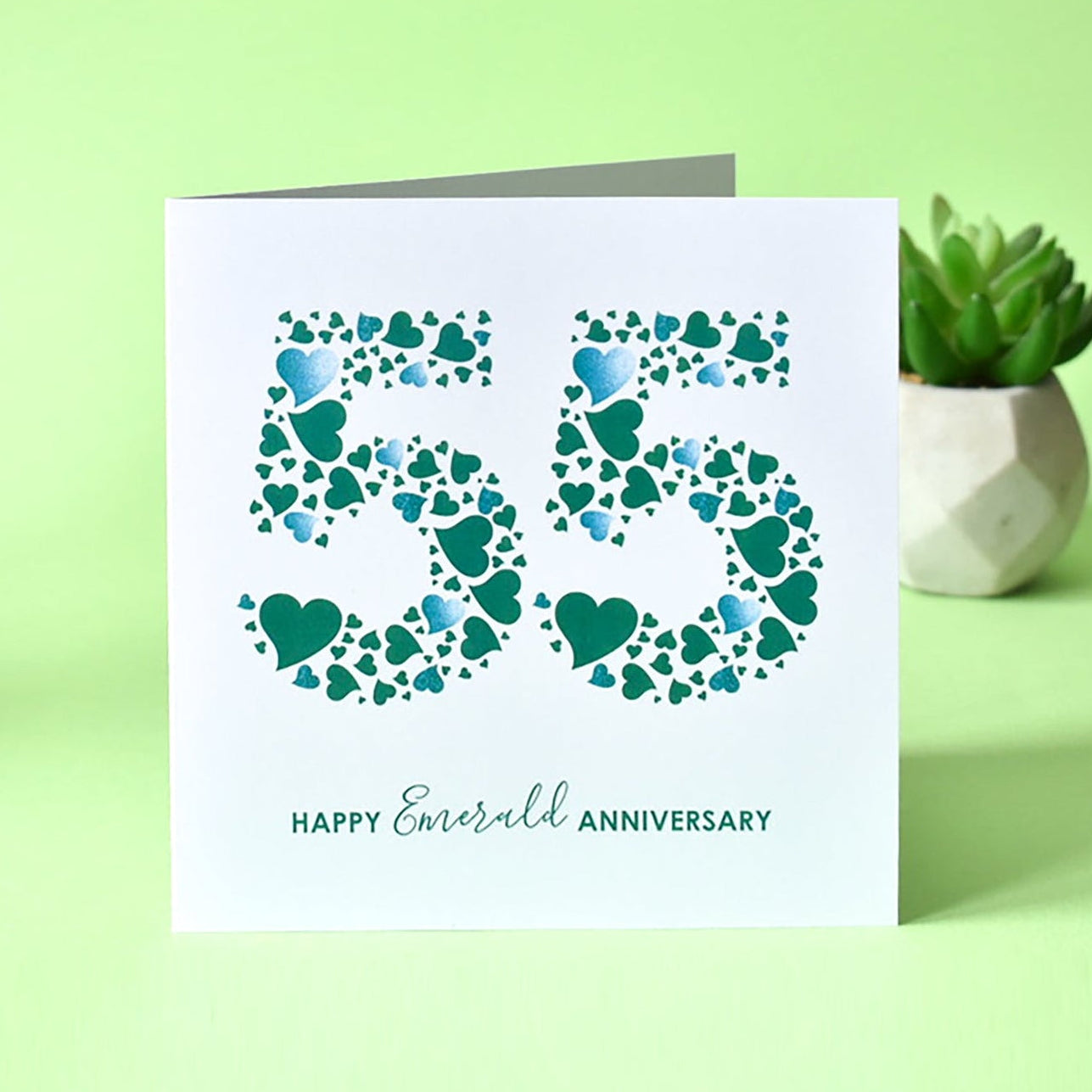 Emerald Wedding Anniversary card with a white background featuring a dense pattern of emerald green love hearts arranged to form the number '55', with the text 'Happy Emerald Anniversary' printed on it.