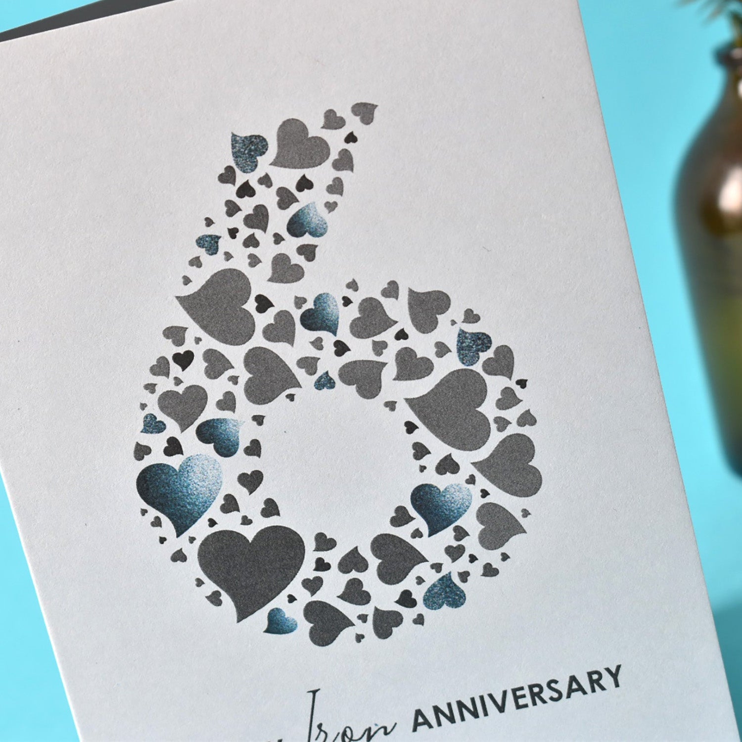 Collection of love hearts in different sizes and shades of grey making up a large number 6.