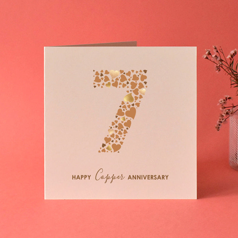 Anniversary card with a number 7 made from lots of different size love hearts in shades of brown and 'Happy Copper Anniversary' underneath. Printed on cream card.