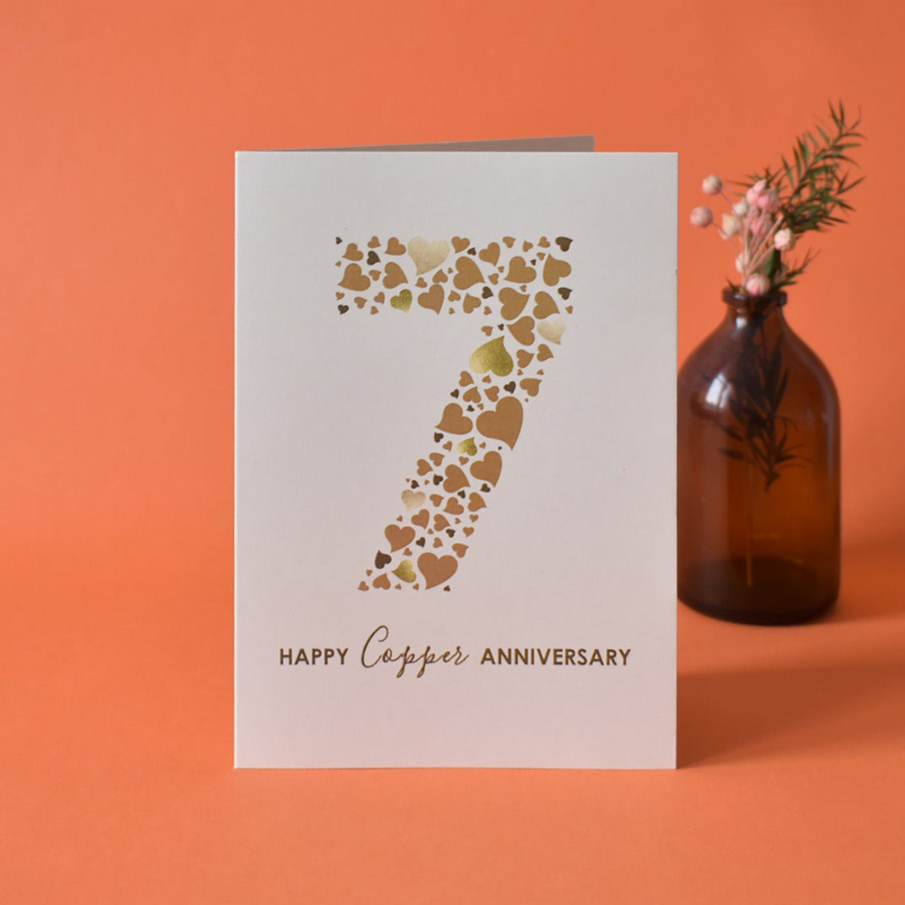 Cream card with heart pattern making a large number 7 and 'Happy Copper Anniversary' text.