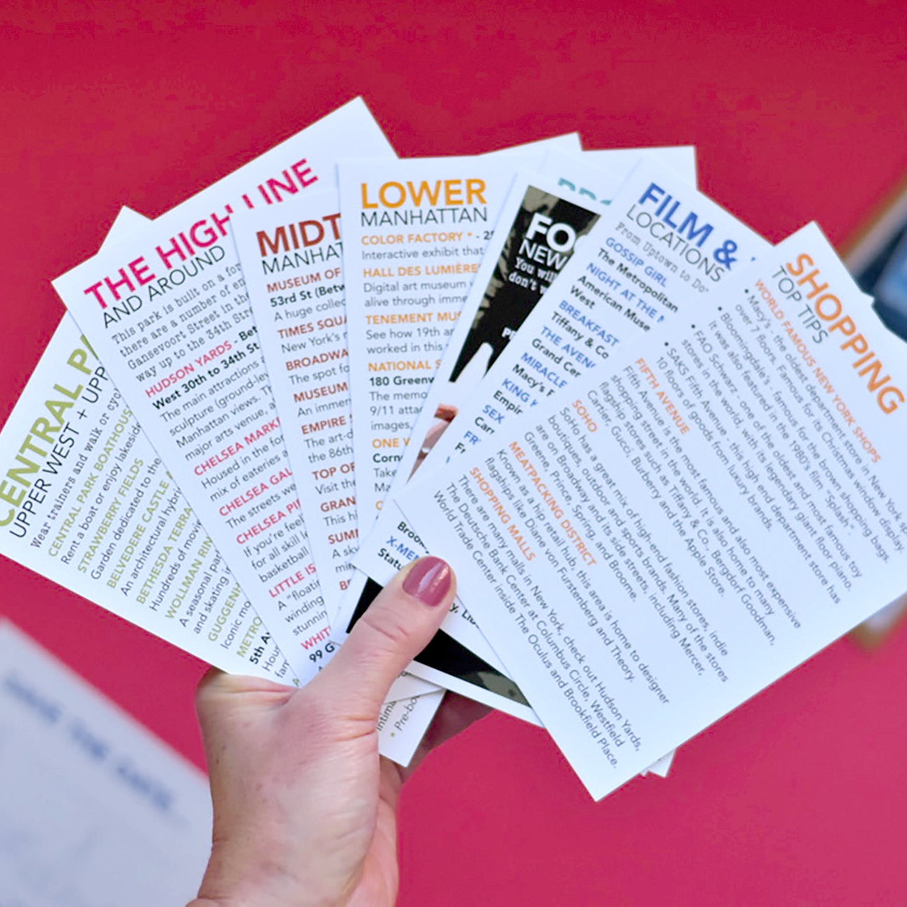 Hand holding multiple informational cards for New York.