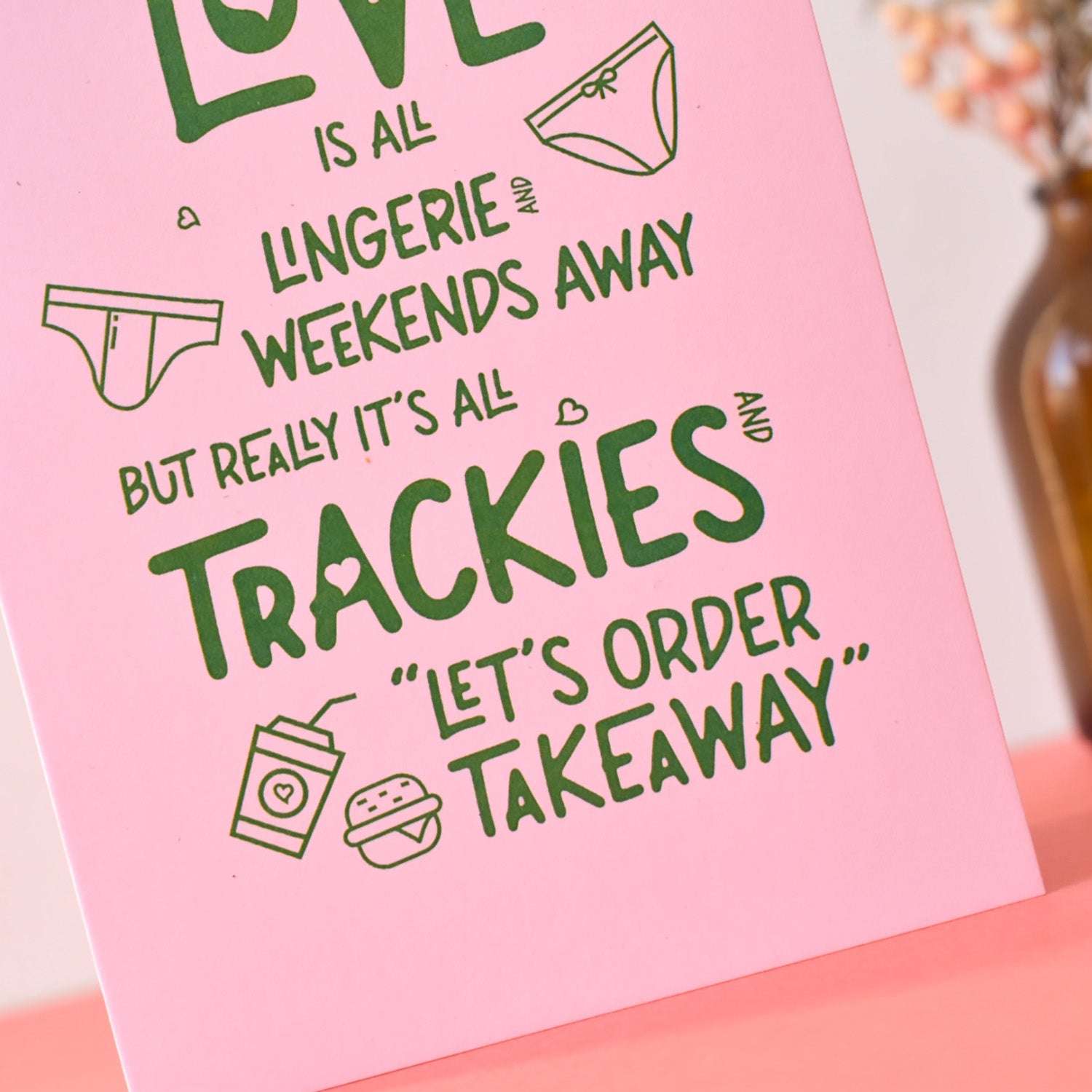 Pink card with green text and lingerie  and takeaway illustrations on a pink background.
