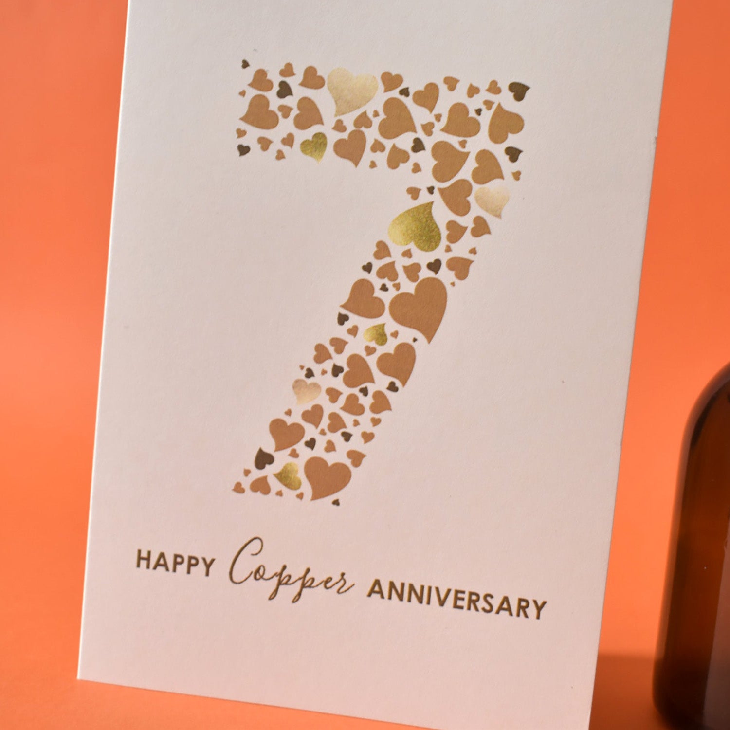 A6 cream card with a huge number 7 designed from an array of copper coloured love hearts.