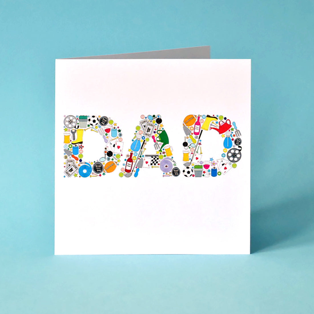White square card with the word Dad written in capital letters and made from illustrations of such things as: footballs, gardening hose, trowel and watering can, pint of beer, bottle of wine, plants, film reel, playing cards, rugby ball, gold clubs and balls, cinema tickets, tennis balls and snooker balls.