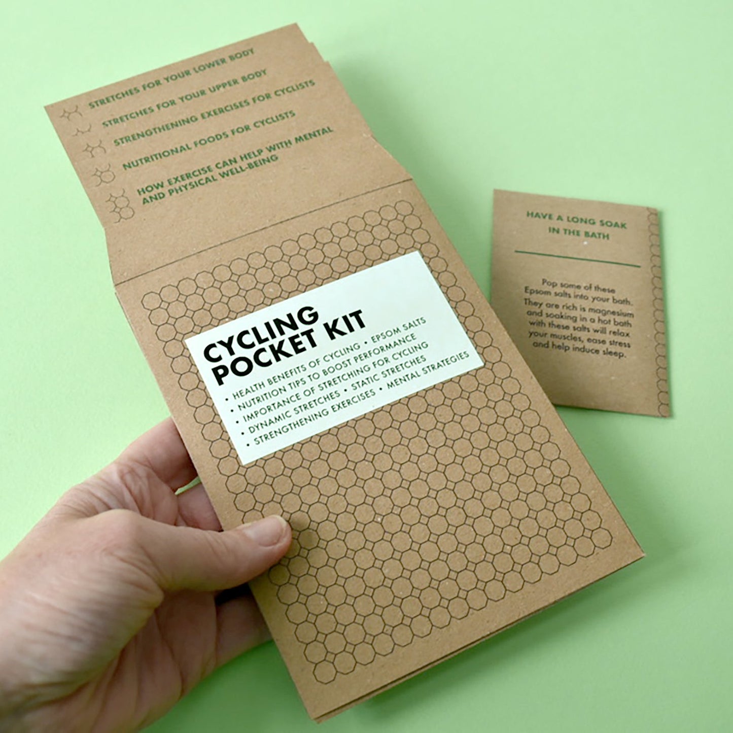 A person holding the Cycling Pocket Kit wallet to show its compact, pocket-sized design.