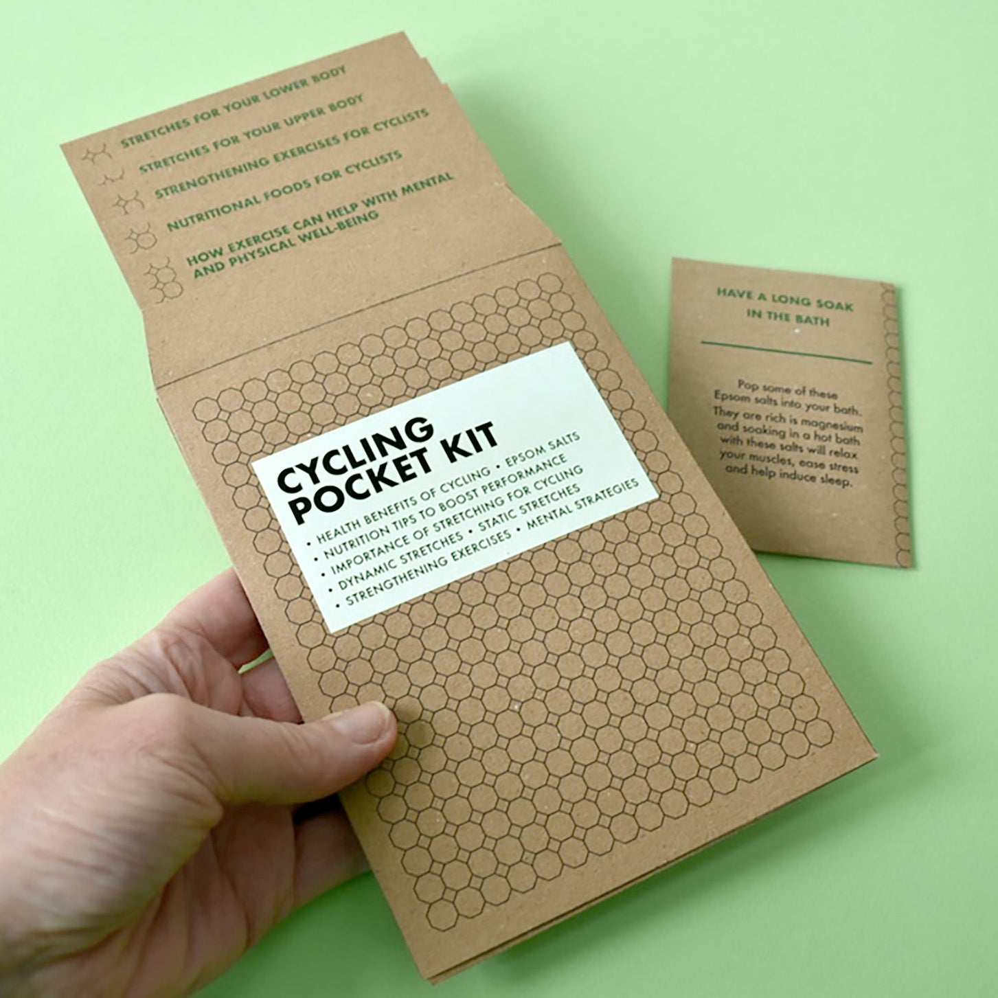 A person holding the Cycling Pocket Kit wallet to show its compact, pocket-sized design.