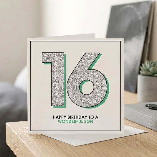 Greeting card with '16 - Happy Birthday to a wonderful son' on a table in a room.
