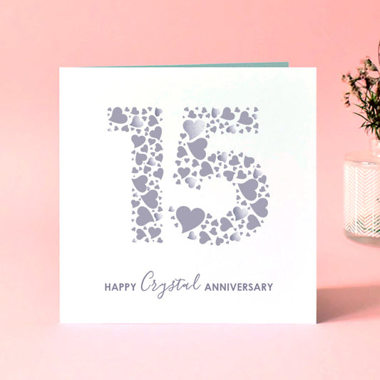 Card with heart design and 'Happy Crystal Anniversary' text on a pink background