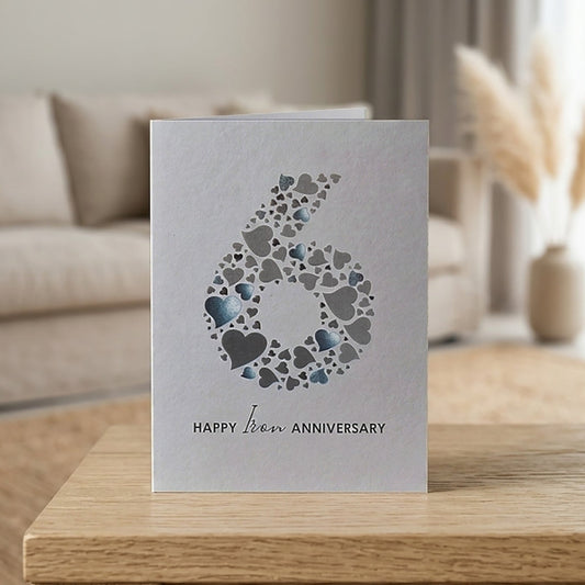 Pale grey card with large number 6 made from a collection of love hearts and the wording underneath that reads "Happy Iron Anniversary'.