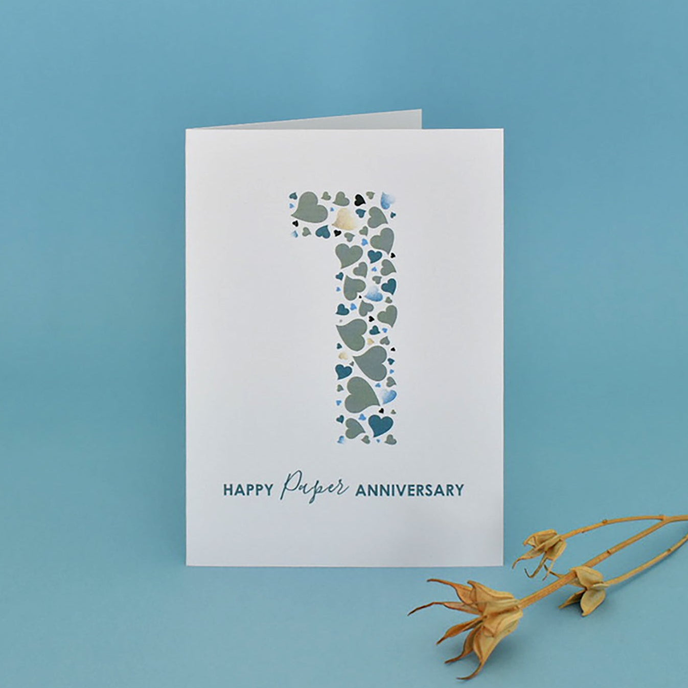 Greeting card with heart design and 'Happy Paper Anniversary' text on a beige background.