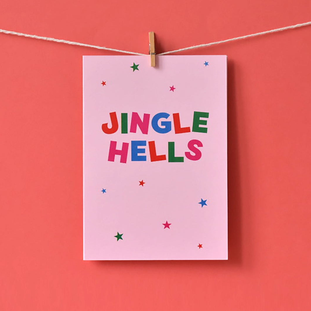 Pink card with 'JINGLE HELLS' text in red, blue, green and pink. 