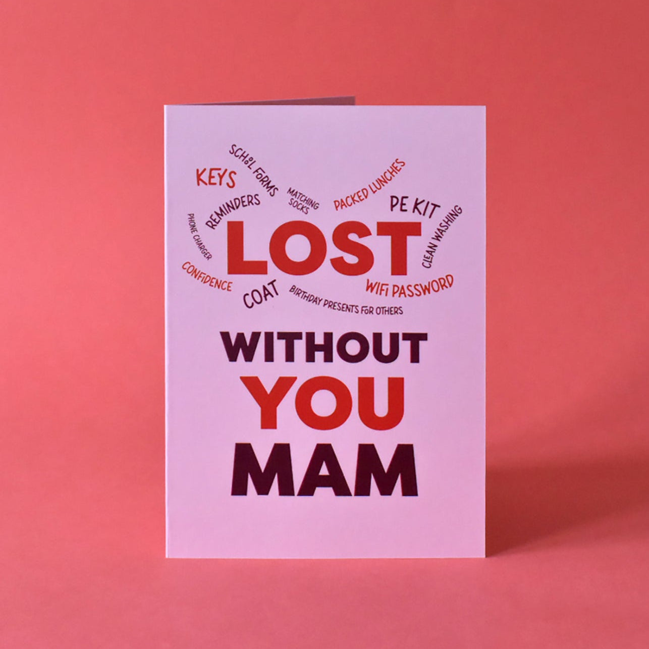 A soft pink greeting card with bold burgundy text that reads 'Lost without you Mam.' A modern and humorous appreciation card for Mams who manage everything from school lunches to remembering the Wi-Fi password.