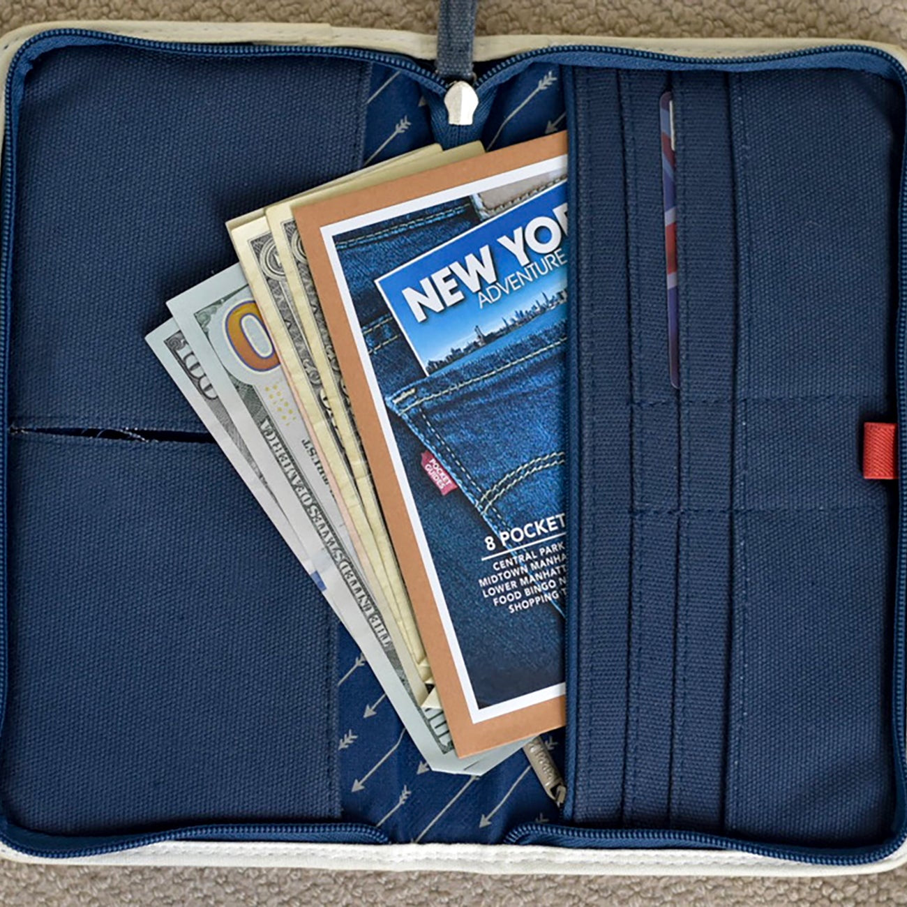 Blue pouch with dollars  and a New York Travel Wallet.