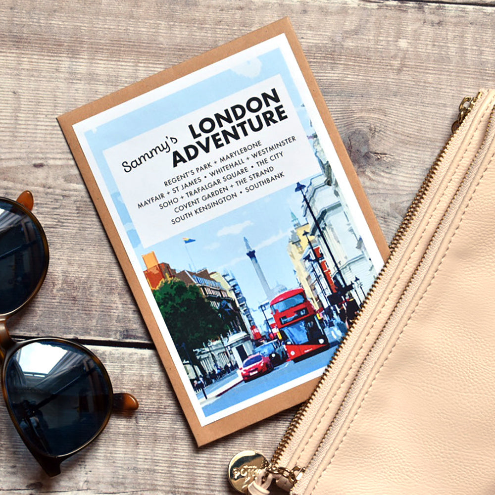 A flat-lay of a Sammy's London Adventure travel guide book, a beige leather zip pouch embossed with 'Chloé', and black sunglasses on a rustic wooden background.