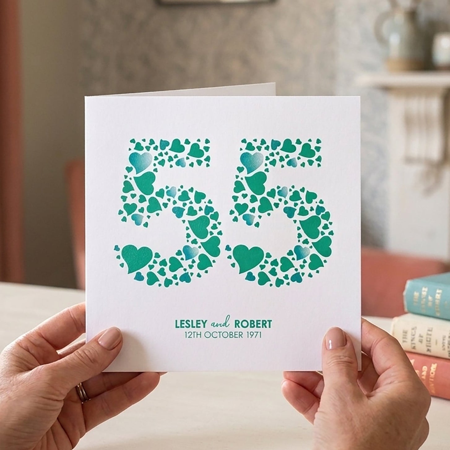 Personalised emerald wedding anniversary card with a large number 55 made from emerald green love hearts on a white background.