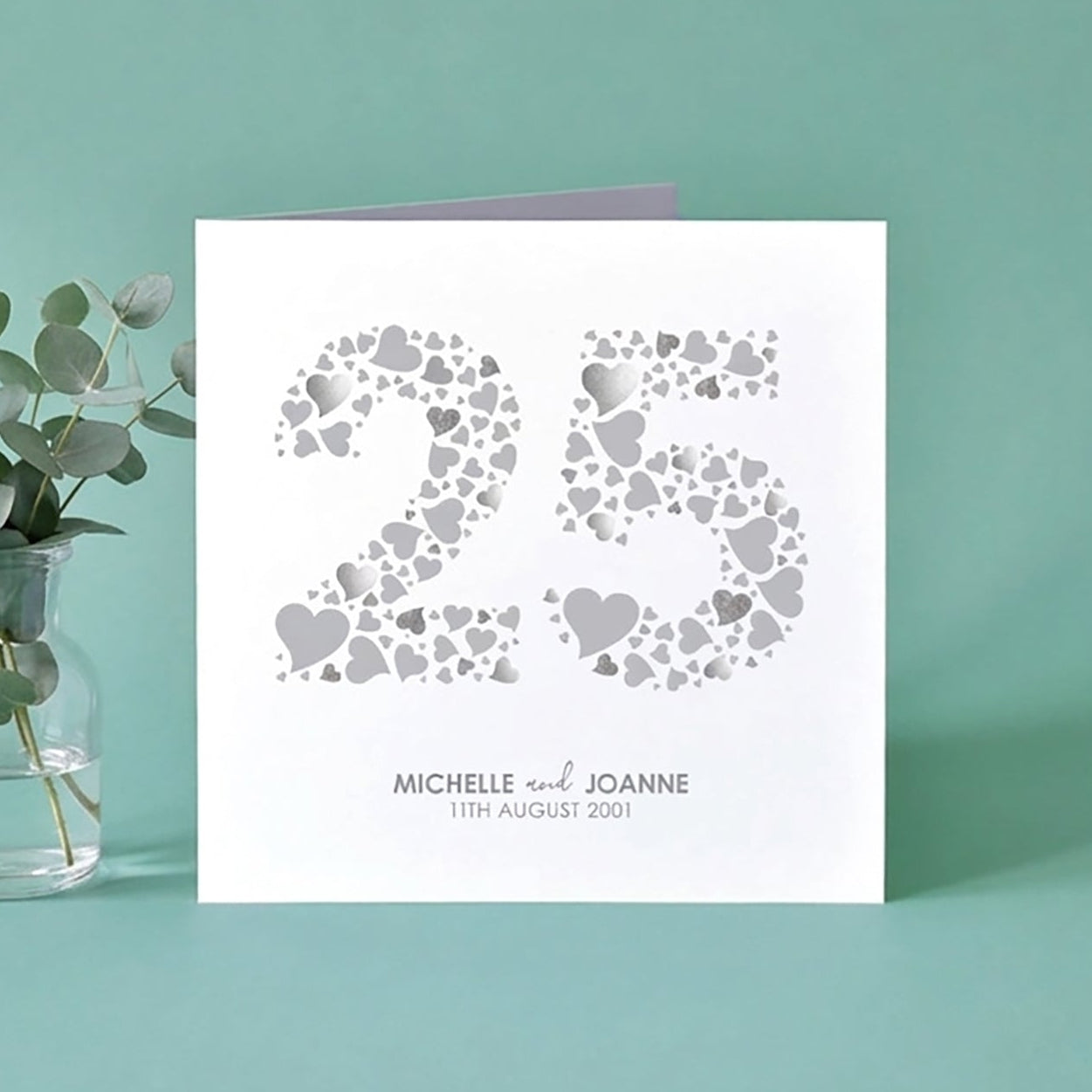 A silver-coloured wedding anniversary card with the number 25 made from love hearts.