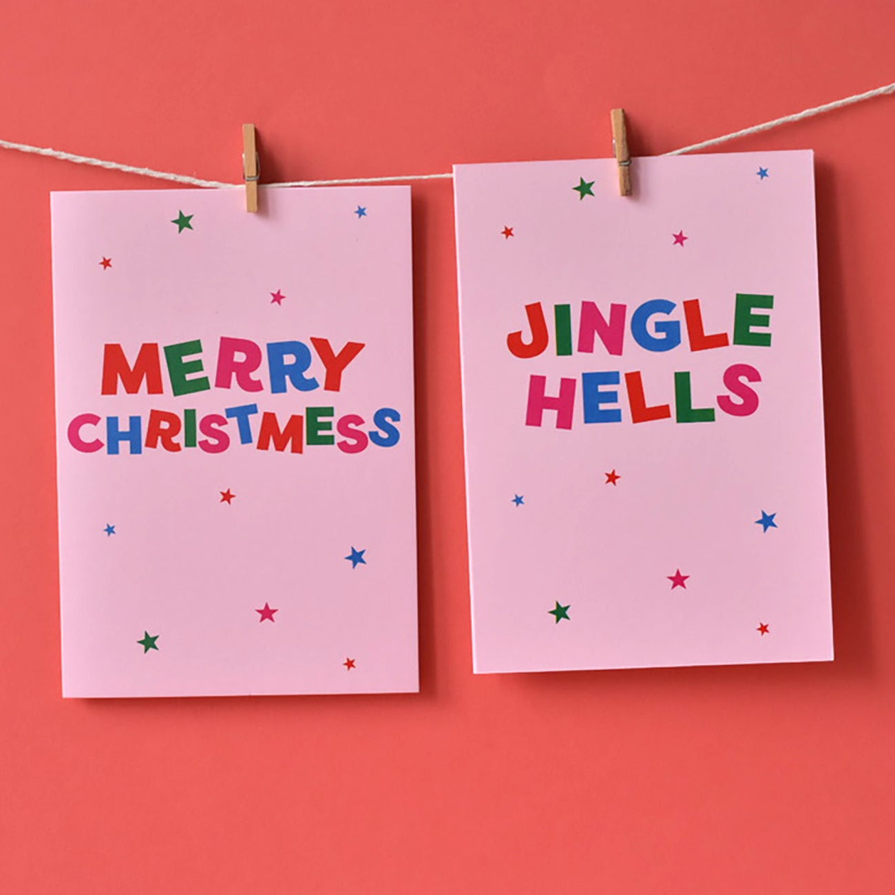 Two pink cards with 'Merry Christmess' and 'Jingle Hells' text in multi-colours.