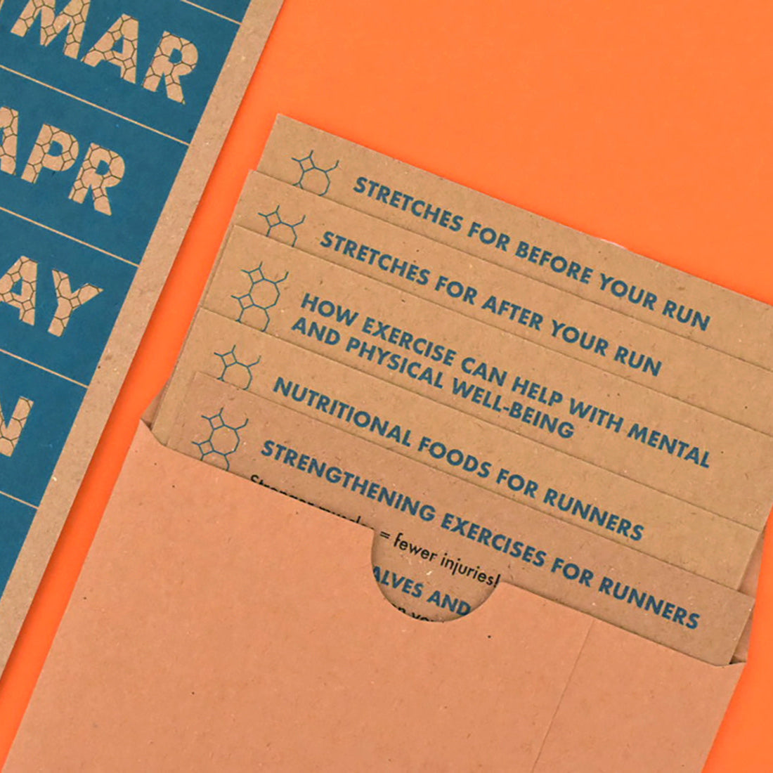 Open A6 wallet showing colourful cards from the Pocket Guide for Runners kit.