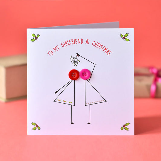Greeting card with a design of two people holding hands with buttons instead of heads, on a pink background.