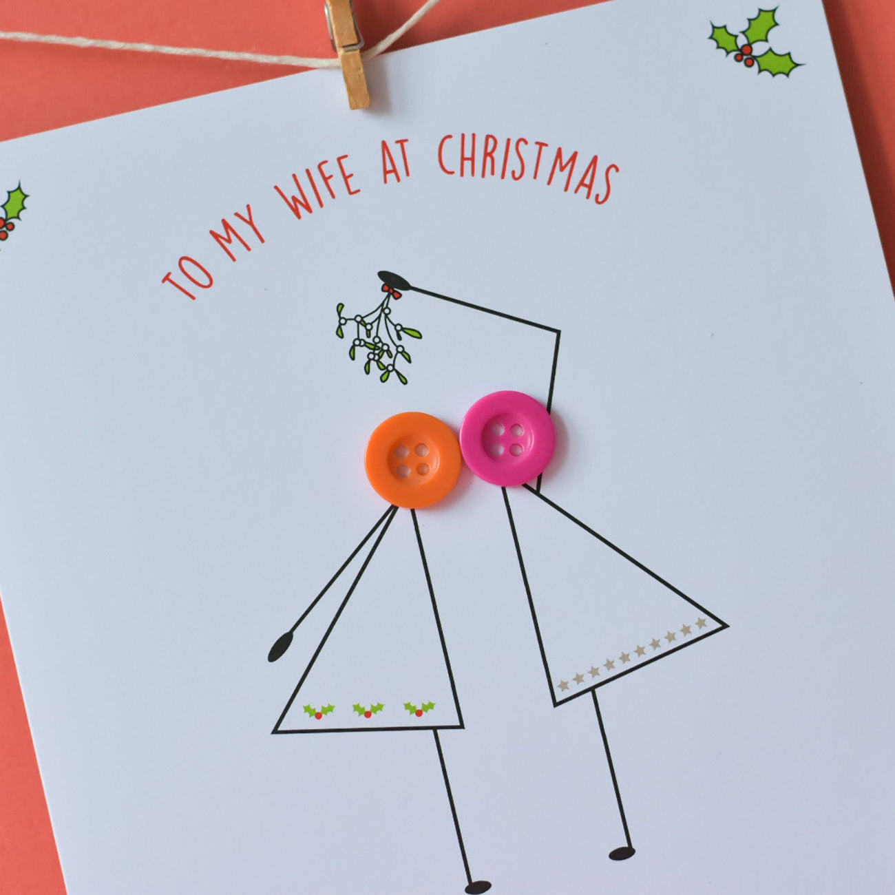 Card with stick figure design and text 'To my wife at Christmas' on a red background